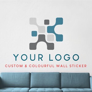 Könnte beinhalten: Ein Wandaufkleber mit einem geometrischen Logo in Grau und Blaugrün über dem Text "YOUR LOGO". Darunter wird der Text "CUSTOM & COLOURFUL WALL STICKER" angezeigt. Unten ist ein teal-farbenes Sofa zu sehen.