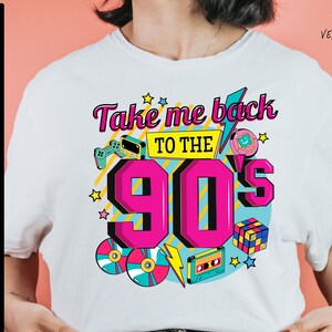 May include: White t-shirt with a graphic design featuring the text "Take me back to the 90's" in pink and yellow. The design includes retro icons like a cassette tape, a game cartridge, a Tamagotchi, and a Rubik's Cube.