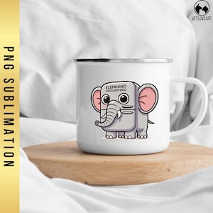 May include: White enamel mug with a cartoon elephant design. The elephant is gray with pink ears and the text "ELEFANINO FRIGORIFERO" is above the elephant. The mug has a silver rim and a white handle. The mug is on a wooden surface.