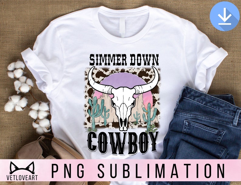 May include: White t-shirt with a graphic design of a cow skull with a pink sunset behind it. The text "Simmer Down Cowboy" is printed below the skull.