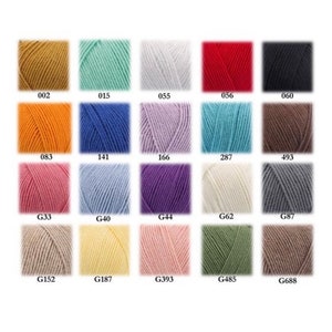 May include: A color chart of yarn samples in various shades of beige, brown, blue, green, pink, red, orange, white, gray, and light blue. The yarn samples are arranged in a grid pattern with the color code for each sample listed below it.