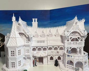 May include: A white detailed model of a large Victorian style house with a wraparound porch and a turret. The model is made of plastic and is about 12 inches tall.
