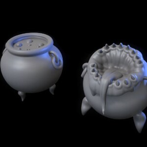 Könnte beinhalten: Zwei graue Keramikkessel mit jeweils drei Beinen. Ein Kessel hat einen strukturierten Rand und der andere einen glatten Rand. Beide Kessel sind rund.