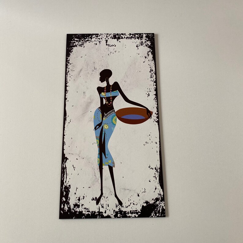 May include: A black silhouette of a woman in a blue and yellow patterned skirt holding a brown bowl with blue water. The background is a white textured surface with black edges.