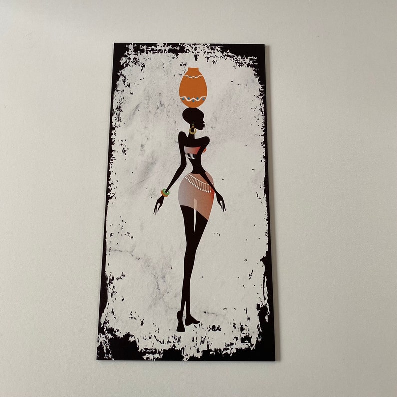 May include: A black and white silhouette of a woman carrying a pot on her head. The woman is wearing a skirt and jewelry. The background is a white and gray textured surface.