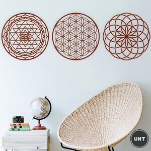 May include: Three brown geometric wall decals with intricate patterns. The decals are circular and feature a flower of life design, a sri yantra design, and a mandala design.