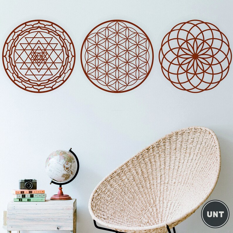 May include: Three brown geometric wall decals with intricate patterns. The decals are circular and feature a flower of life design, a sri yantra design, and a mandala design.