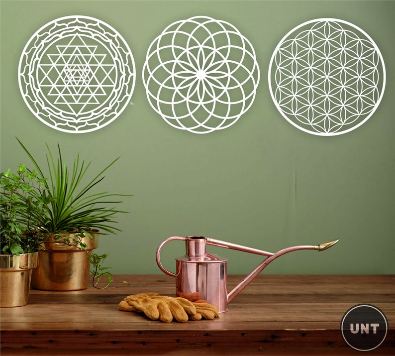 May include: Three white geometric wall decals with intricate patterns. The decals are circular and feature a flower of life design, a sri yantra design, and a mandala design.