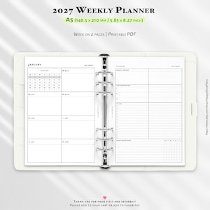 Può includere: Un'agenda settimanale 2027 formato A5 che misura 148,5 per 210 mm. L'agenda aperta presenta un meccanismo di rilegatura a sei anelli argentati, un calendario di gennaio e sezioni per obiettivi, priorità, liste di cose da fare e routine.