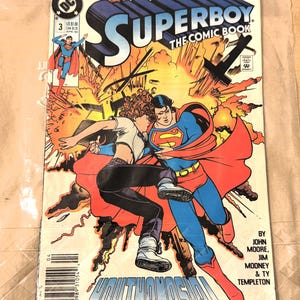 May include: A Superboy comic book with a dynamic illustration of Superboy in action, featuring a red and blue costume, and a woman in black pants. The cover includes the text "Superboy The Comic Book" and "Youthanasia!"