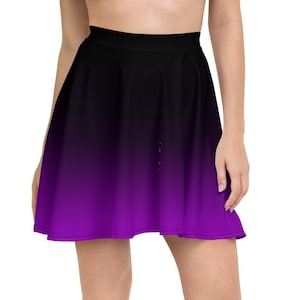 Puede incluir: Una falda skater de color negro y morado degradado. La falda está hecha de una tela suave y elástica y tiene un ajuste cómodo.