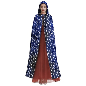 May include: A blue hooded cape with white stars and crescent moons. The cape is worn over a red dress.