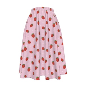 May include: A pink skirt with a strawberry print. The skirt is A-line and has a high waist.