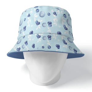 May include: A light blue bucket hat with a blueberry print. The hat has a blue underside.