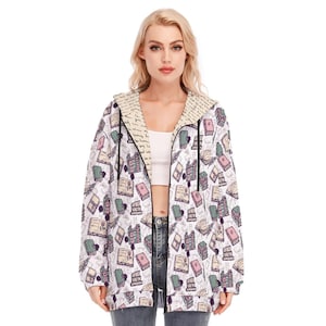 May include: White hooded sweatshirt with a zipper closure. The sweatshirt has a pattern of colorful books and handwritten text.