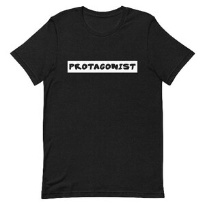 May include: Black t-shirt with the word "PROTAGONIST" printed in white on the front.