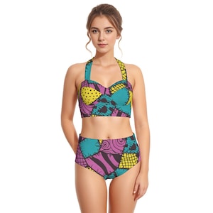 May include: A two-piece swimsuit featuring a patchwork design in teal, purple, yellow, and black. The halter top has a sweetheart neckline, and the high-waisted bottoms complete the set. The swimsuit is made of a soft, stretchy material.