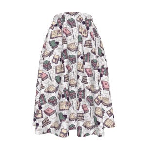 May include: A white midi skirt featuring a charming pattern of stacked books, open books, and pens in shades of pink, green, and brown.
