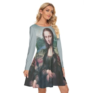 May include: A light blue long-sleeved dress with a print of the Mona Lisa painting. The dress has a round neckline and a flared skirt.