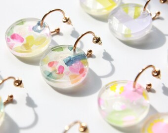 Pendientes de aro dorados con colgante gráfico de resina.