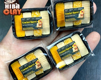 Puede incluir: Tres contenedores de plástico en miniatura de rebanadas de queso Cracker Barrel. Cada contenedor tiene cuatro tipos diferentes de queso: pepper jack, cheddar, asiago y cheddar extra fuerte. Los contenedores están etiquetados como "Cracker Barrel 48 Cracker Cuts".
