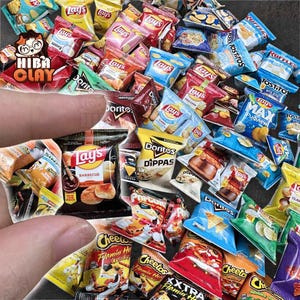 Può includere: Una collezione di confezioni di snack in miniatura, tra cui Lay's, Doritos, Cheetos e Tostitos. Le borse colorate presentano vari gusti e design, creando un assortimento dettagliato. L'immagine mostra una varietà di marchi di patatine popolari.
