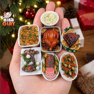 May include: A collection of miniature clay food items including a roasted turkey in a pan, a glazed ham with orange slices, sliced meat with vegetables, a chocolate yule log, a bowl of stuffing, and a small bowl of creamy side dish.