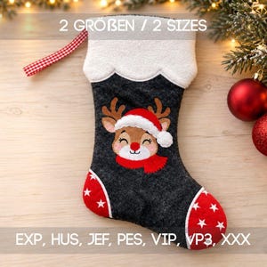 May include: A dark gray felt Christmas stocking featuring a white cuff, a red and white checkered hanging loop, and an embroidered reindeer wearing a Santa hat and red scarf. The toe and heel are red with white stars. Text reads 2 SIZES.