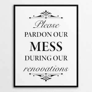 Może przedstawiać: Oprawiony czarno-biały znak z napisem "Please Pardon Our Mess During Our Renovations". Tekst jest w ozdobnej czcionce, z ozdobnymi zawijasami nad i pod tekstem.
