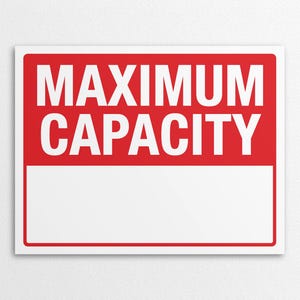 Op de afbeelding: Een rechthoekig bord met een rode achtergrond en witte tekst met de tekst "MAXIMUM CAPACITY". Onder de tekst bevindt zich een witte rechthoekige ruimte. Het bord staat tegen een witte achtergrond.