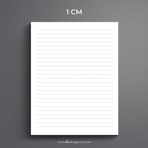 May include: A white sheet of paper with black lines spaced 1 centimetre apart. The paper is on a grey background. The text "1 CM" is at the top of the page.