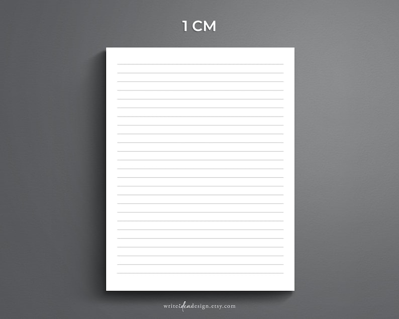 May include: A white sheet of paper with black lines spaced 1 centimetre apart. The paper is on a grey background. The text "1 CM" is at the top of the page.
