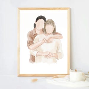 Puede incluir: Retrato en acuarela de dos personas abraz&aacute;ndose, enmarcado en madera clara. Las figuras est&aacute;n representadas en tonos suaves y apagados de marr&oacute;n y crema, sin rasgos faciales. La obra evoca una sensaci&oacute;n de calidez y conexi&oacute;n, adecuada para la decoraci&oacute;n del hogar.