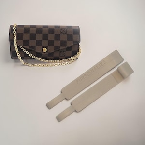 May include: A brown and black checked wallet with a gold chain strap and a gold button clasp. Two grey purse organisers are next to the wallet. The text "PERSONALIZE" is printed on the organisers.