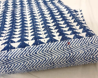 May include: A blue and white kantha quilt with a geometric pattern of triangles and zigzags. The quilt is folded in half and the fabric is soft and textured.