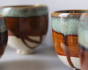 White stoneware coffee cup in brown and green tones