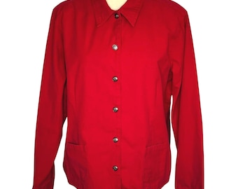 May include: A bright red button-down shirt with long sleeves and two front pockets. The shirt has a classic collar and is fastened with silver-toned buttons. The garment is displayed on a mannequin, showcasing its tailored fit and vibrant color.
