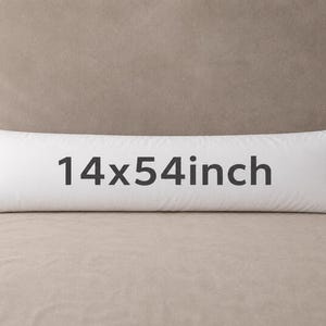 Puede incluir: Una almohada corporal larga y rectangular de color blanco con el texto 14x54inch impreso en gris oscuro en la parte frontal. La almohada tiene una funda de tela blanca lisa y una pequeña etiqueta de marca azul oscuro en el lado derecho.