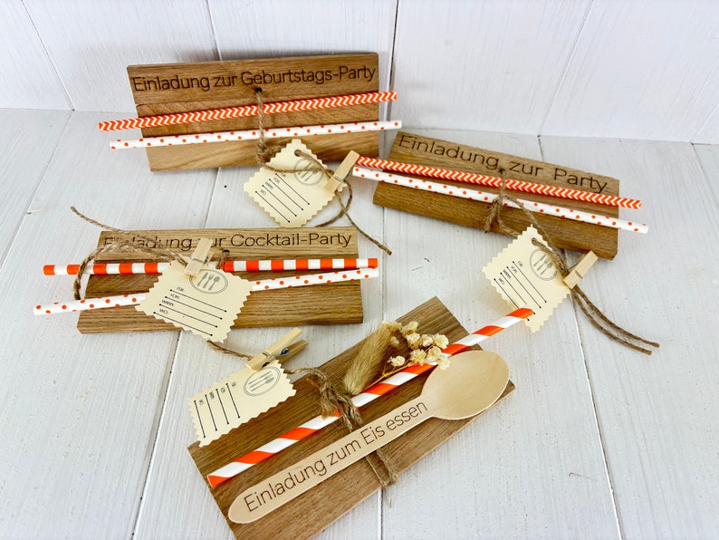 K&ouml;nnte beinhalten: Vier Holz-Einladungen mit orange-wei&szlig;en gestreiften Papierstrohhalmen. Die Einladungen sind f&uuml;r eine Geburtstagsfeier, eine Cocktailparty und eine Eisparty. Jede Einladung hat ein kleines Etikett mit einem leeren Platz zum Schreiben.