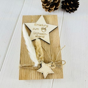 K&ouml;nnte beinhalten: Eine Holz-Einladungskarte mit einem sternf&ouml;rmigen Holzschild, auf dem "Einladung zum Gl&uuml;hwein-abend" steht. Die Karte ist mit getrockneten Blumen und Schnur verziert.