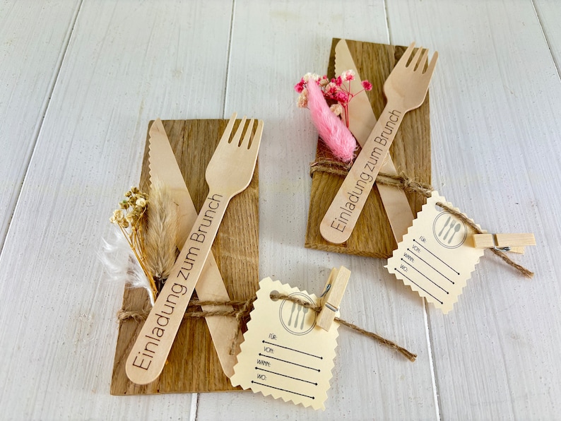 K&ouml;nnte beinhalten: Zwei Holz-Platzkarte mit dem Text "Einladung zum Brunch" (Einladung zum Brunch) und einer Holz-Gabel und einem Holz-Messer auf jeder. Die Platzkarte sind mit Schnur gebunden und mit getrockneten Blumen verziert. Es gibt auch eine leere Platzkarte mit einem Gabel- und Messer-Symbol.