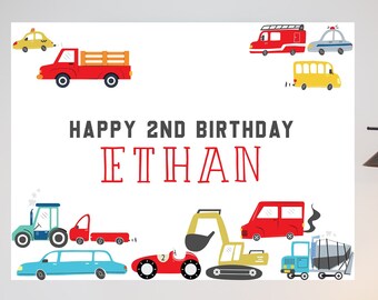 May include: A white printable backdrop with a red truck, a yellow school bus, a red fire truck, a blue car, a yellow taxi, a red car, a blue car, a red car, a blue car, a red car, a blue car, a yellow excavator, a blue truck, a red truck, a blue car, a red race car, and the text "Happy 2nd Birthday Ethan".