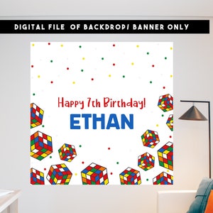 Op de afbeelding: Een witte verjaardagbanner met een kleurrijk Rubik's Cube-patroon en de tekst "Happy 7th Birthday! ETHAN".