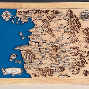 May include: Wooden map of a fantasy world, featuring a blue sea and brown landmass with detailed city and mountain illustrations. The map is framed in light wood and includes a compass rose and a wolf emblem.
