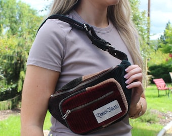 May include: A multi-colored corduroy fanny pack with a zipper closure and a white label that reads "Camden Threads".