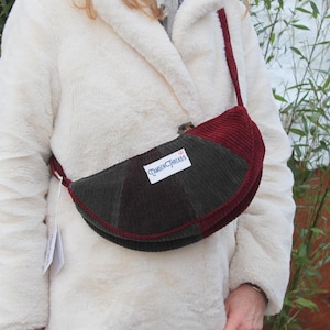 May include: A burgundy and green corduroy crossbody bag with a flap closure. The bag has a label that reads "Camden Threads".