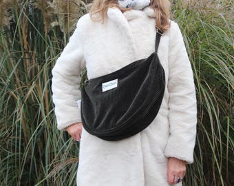 May include: A dark green corduroy crossbody bag with a white label that says "GreenQuill".