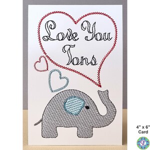 May include: A greeting card featuring an embroidered gray elephant with a blue ear and a trunk that forms a speech bubble. The speech bubble contains the words "Love You Tons" in black script, surrounded by a red heart. The card measures 4" x 6".