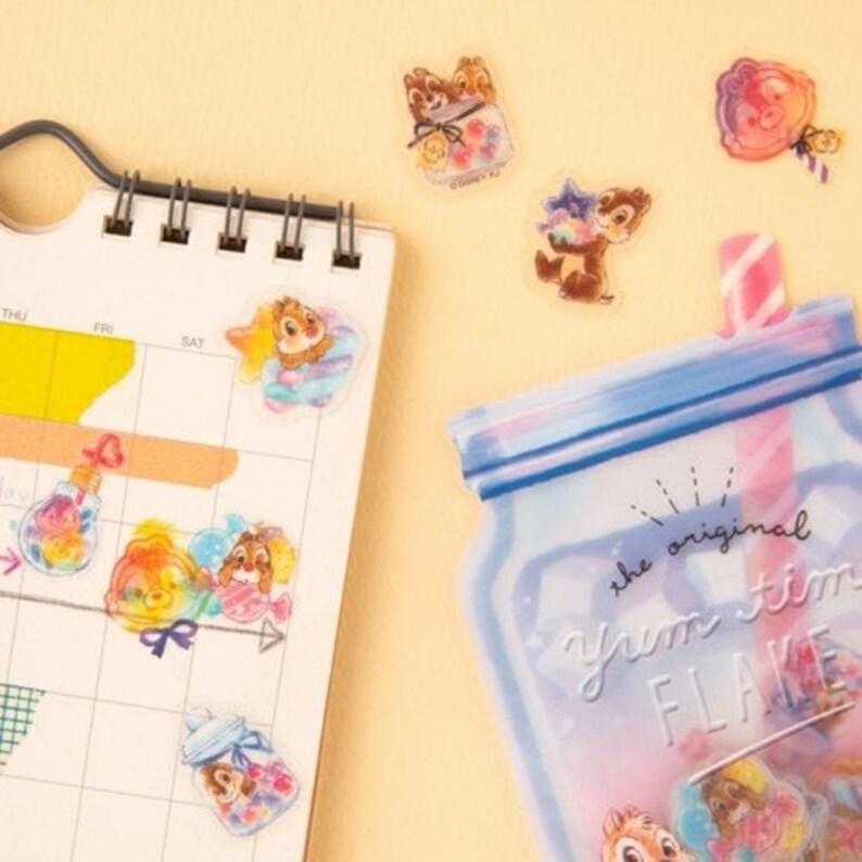 May include: A set of clear stickers featuring Chip and Dale from Disney's Chip 'n Dale Rescue Rangers. The stickers feature the characters in various poses, including holding a jar of candy, a lollipop, and a glass of milk. The stickers are perfect for adding a touch of Disney magic to your planner, journal, or scrapbook.