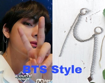 May include: A pair of silver chain earrings with a hoop at the top and a square charm at the bottom. The earrings are styled in a "BTS Style" as seen in the image.